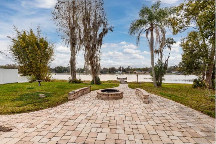 Backyard with fire pit and wavered walkway to the lake