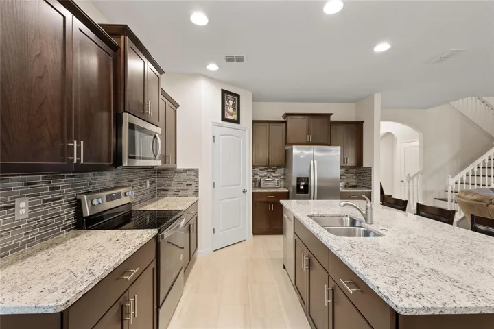 Kitchen with espresso cabinets, granite counters, large breakfast bar, newer backsplash. Stainless appliances are all included!