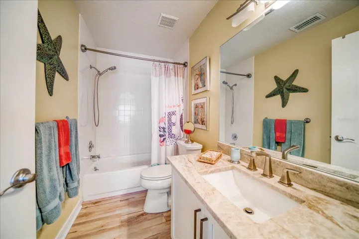 3rd Bathroom with vinyl plank flooring and granite countertop.