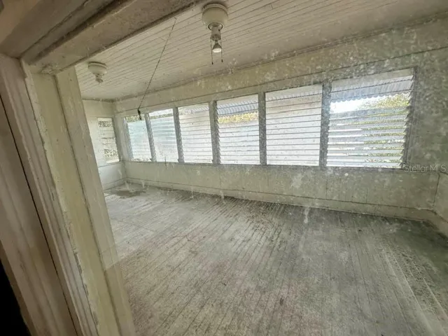 UPSTAIRS APT - View of top front porch from the living room.  Jalousie windows