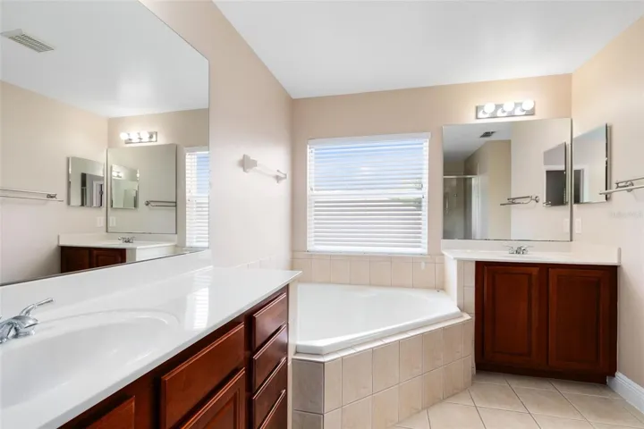 The ensuite master bath features separate vanities and a luxurious garden tub.
