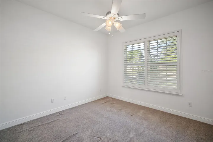 Bedroom 2 with ceiling fan and carpeting