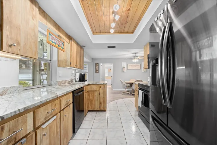 Kitchen with granite, tile, newer appliances and decorative wood ceiling