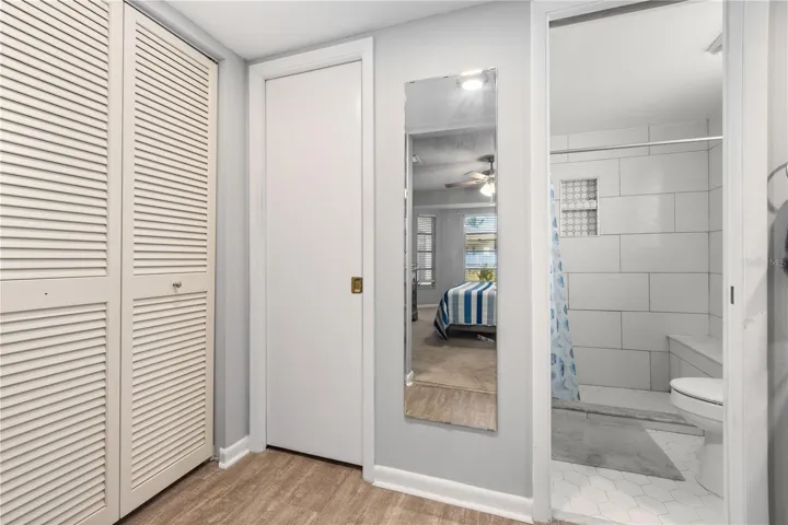 primary bathroom view 2 with linen closet, walk in closet and walk in tiled shower