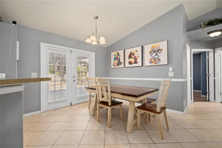 Dining area with French doors leading to covered porch, freshly painted deck and refreshing swimming pool.