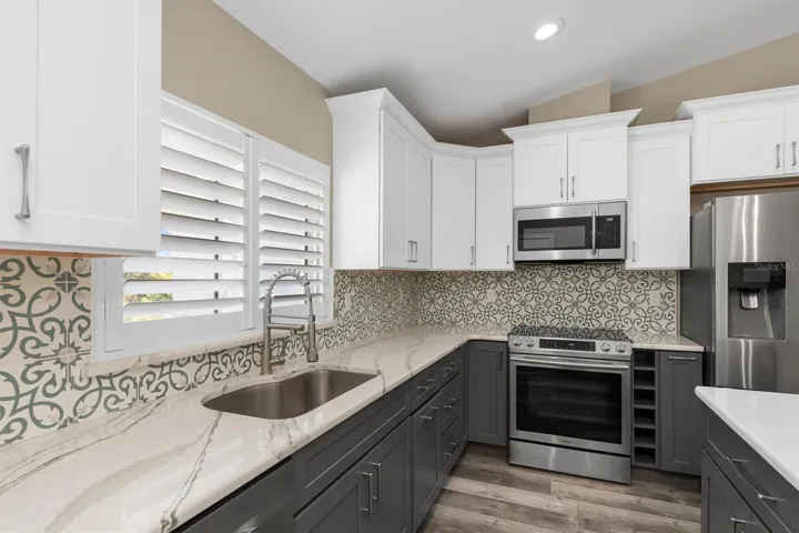 Bottom cabinets are a dark grayish-brown with white top cabinets to keep the space light and airy.