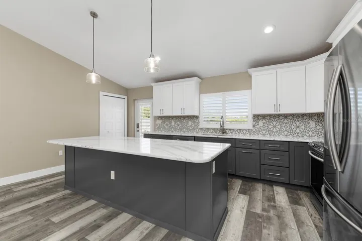 Tile backsplash is a soft greyish-green color.