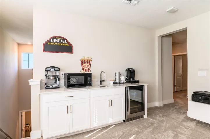 Upstairs bonus room wet bar with mini fridge and microwave