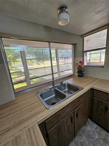 Kitchen - View of Breakfast bar and sliding window to outside, overlooking the yard.