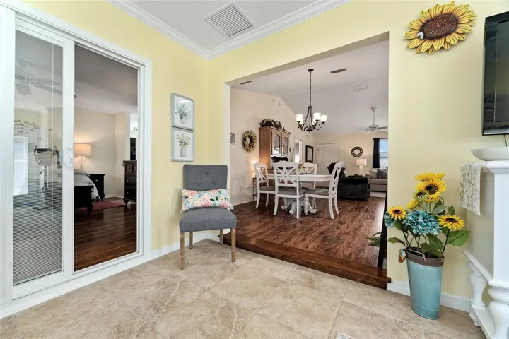 View of FLORIDA ROOM shows large entryway into DINING ROOM (R) & SLIDING GLASS DOORS to PRIMARY BEDROOM (L)