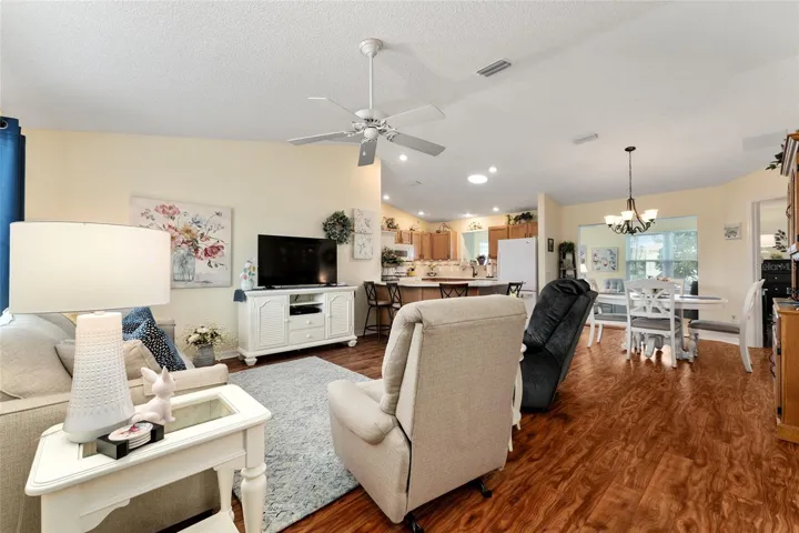View from FRONT DOOR - LIVING ROOM (front L), KITCHEN (back center), & DINING ROOM (back R). Note CATHEDRAL CEILING over main living area and SOLAR TUBE over KITCHEN.