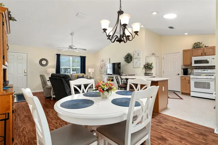 View of DINING ROOM (front center) shows LIVING ROOM (back L) and KITCHEN (R) with exit door to garage.