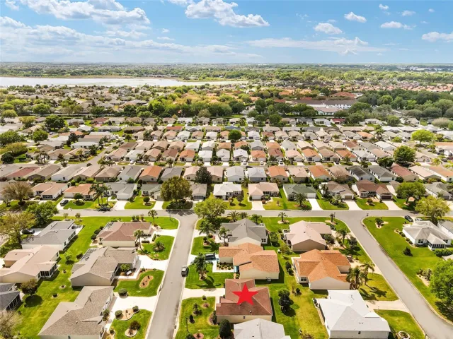 AERIAL looking SOUTH - SOUTHERN OAKS VILLAS are located SOUTH of subject property. CR 472/Rainey Trail runs East-West in front of LAKESIDE LANDINGS entrance (center on S side w/ colorful orange tile roofs). Lake Miona is visible in the upper L quadrant of photo