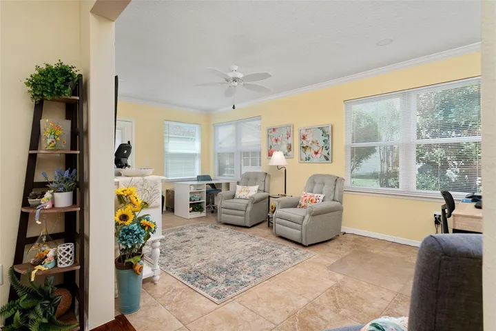 FLORIDA ROOM features large CERAMIC TILE FLOOR, DOUBLE PANE WINDOWS, CROWN MOLDING, a CLOSET, and rear door w/ BUILT-IN BLINDS gives access to REAR PATIO.
