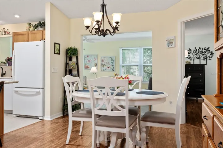 View of DINING ROOM shows KITCHEN (L), entranceway to FLORIDA ROOM (back center), and doorway to PRIMARY BEDROOM (back R)