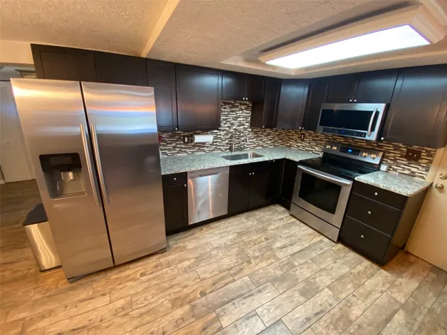 Kitchen with Stainless Steel Samsung Appliances and grainate counters.