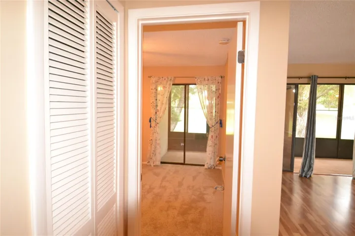 Laundry doors closed and view into the second bedroom on the left