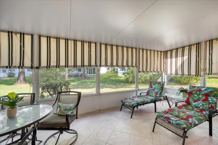 Screened lanai with tile flooring & outdoor fabric shades~