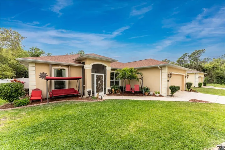 This beautiful entrance has a nicely landscaped front lawn with custom concrete curbing and a screened front porch enclosure, leading to the front door and includes a two car garage.