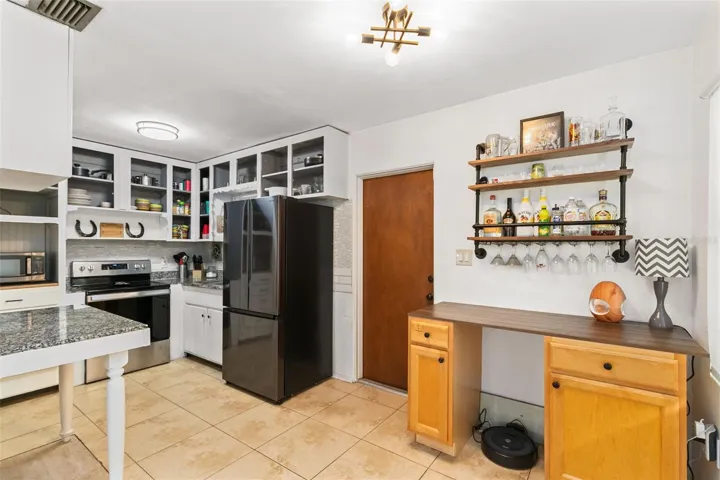 The eat-in kitchen boasts stainless steel appliances, granite counters, and a modern tile backsplash, perfect for culinary enthusiasts.