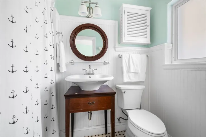 Vintage bathroom with beadboard and tile flooring.