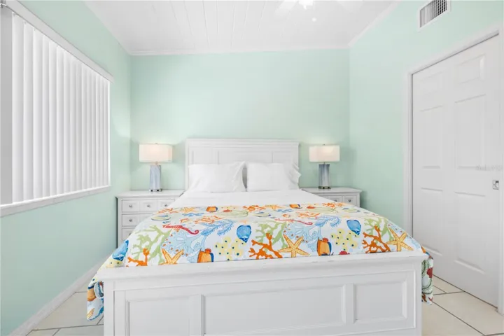 Queen sized bed with end tables and closet to the right.