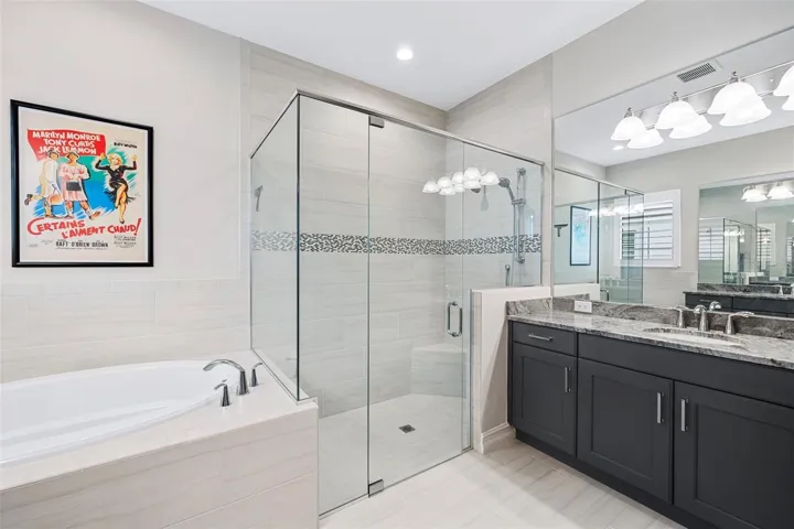 Ensuite primary bathroom with soaking tub, shower with floor-to-ceiling tile