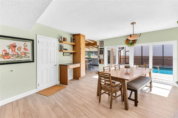 Dinning room with a four panel impact resistance sliders that open into the pool deck area.  Lots of natural light.
