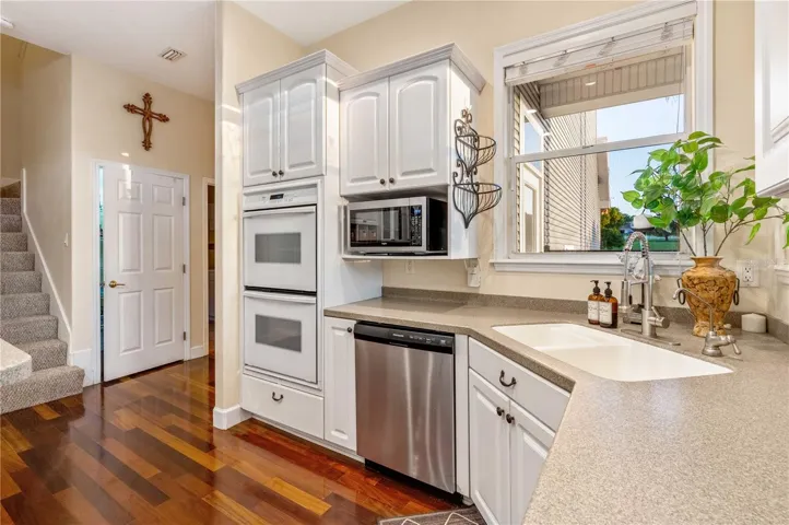 Kitchen with Corian Counters, Custom Cabinets, Gas Cooktop and Double Oven