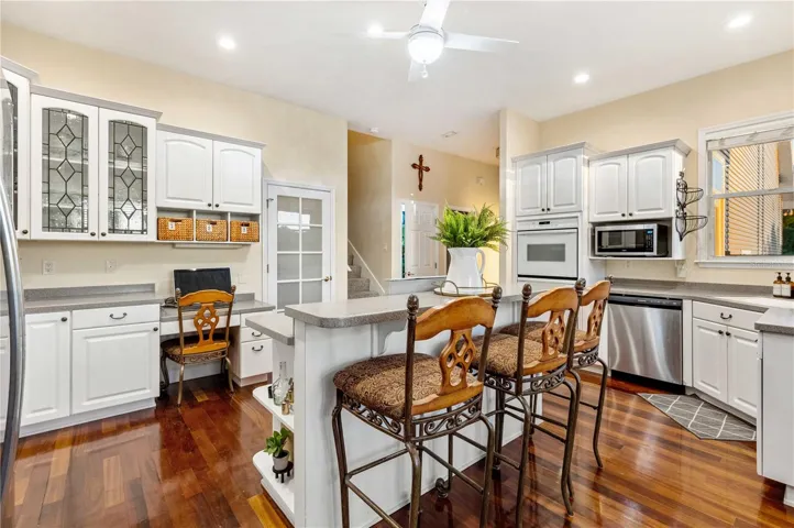 Kitchen with Corian Counters, Custom Cabinets, Gas Cooktop and Double Oven