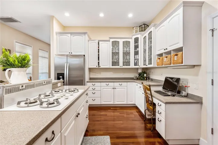 Kitchen with Corian Counters, Custom Cabinets, Gas Cooktop and Double Oven