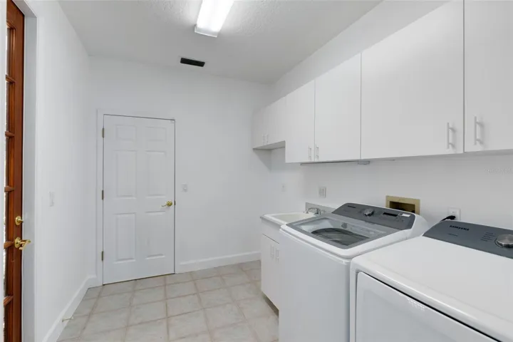 Laundry room with side door to pool