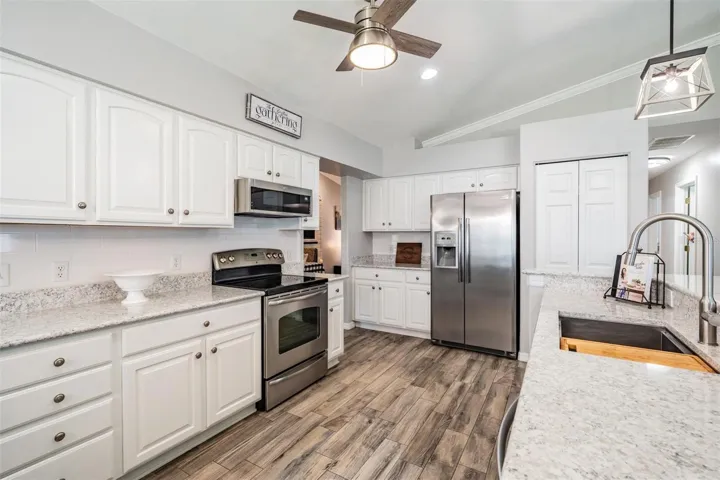 Stainless appliances are highlighted by the crisp, white kitchen