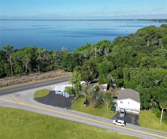 Virtually staged - The grass is not this green meanwhile what you have here is a 3/2 home and a storefront plus a storage building enclosed with white vinyl privacy fencing at the corner of 452 and 19A just barely within he Eustis commercial corridor