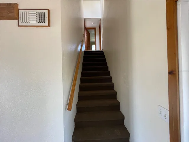Stairway going up to both bedrooms and bathroom