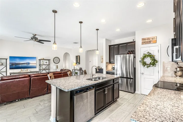 Stone countertop island with room for seating and pendant lights