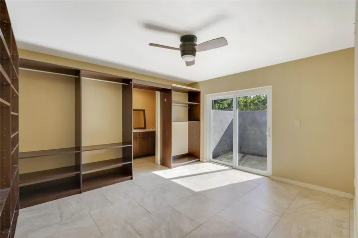 Master bedroom with built-in closet system and sliding doors out to private patio