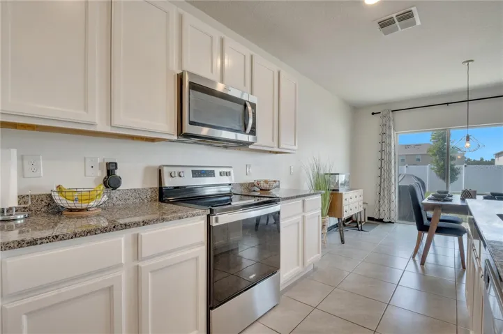 Kitchen with granite countertops and walk-in pantry.