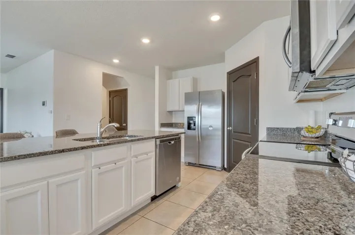 Kitchen with granite countertops and walk-in pantry.