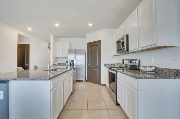 Kitchen with granite countertops and walk-in pantry.