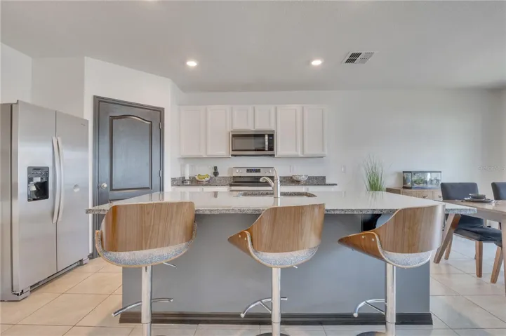 Kitchen with granite countertops and walk-in pantry.