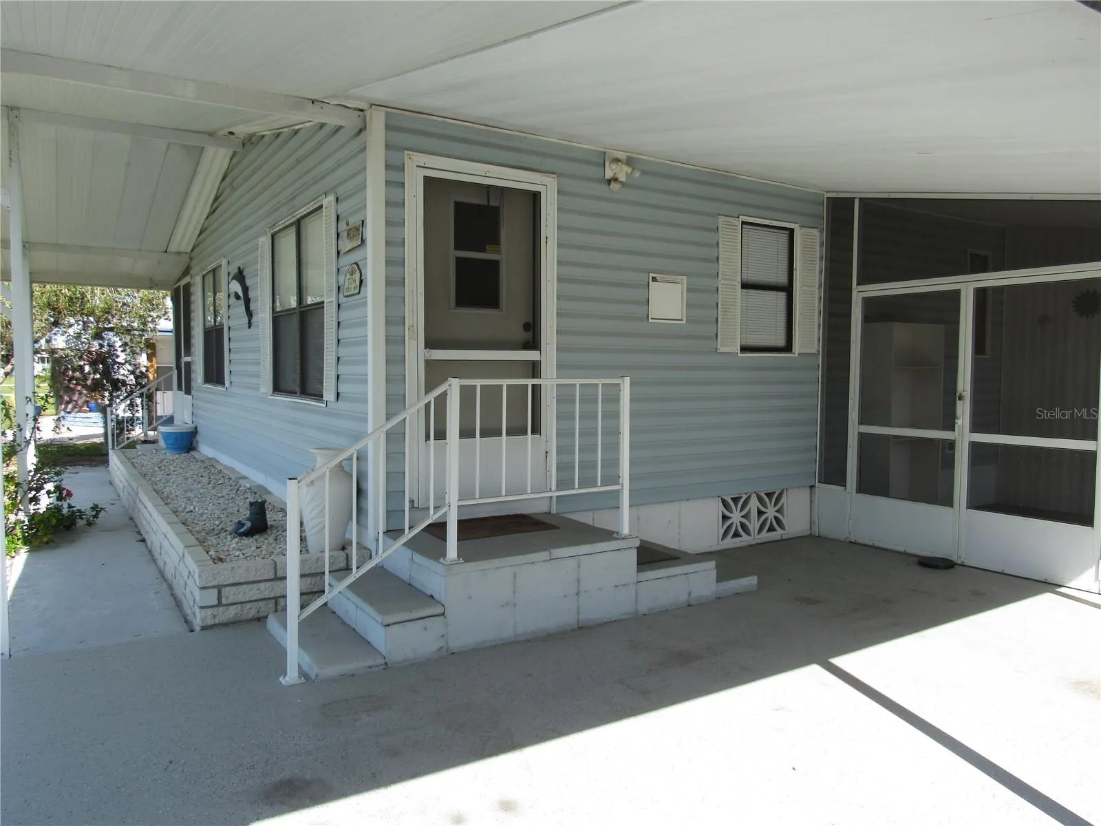 Wide front overhang, sidewalk, brick front planter, main entry, &amp; attached screen porch.