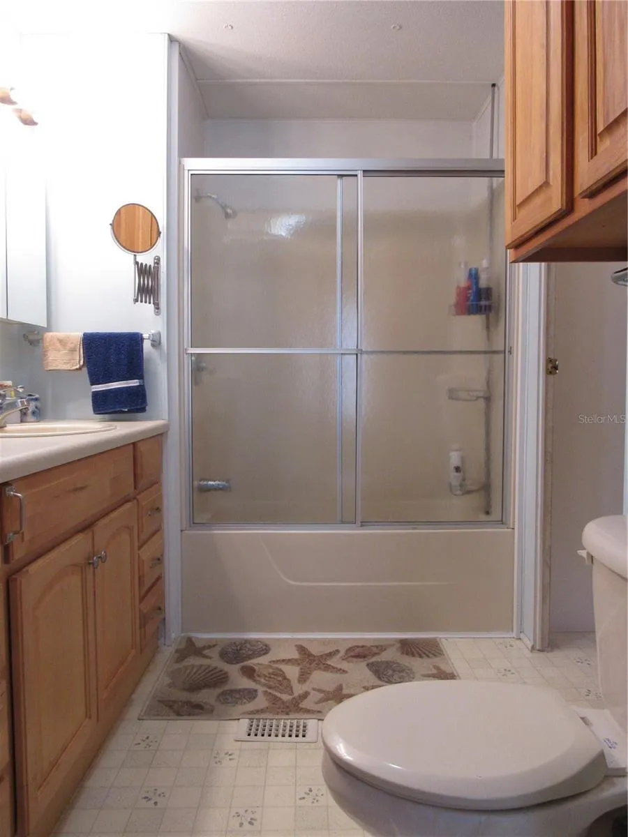 Bathtub &amp; shower surround with sliding glass door.