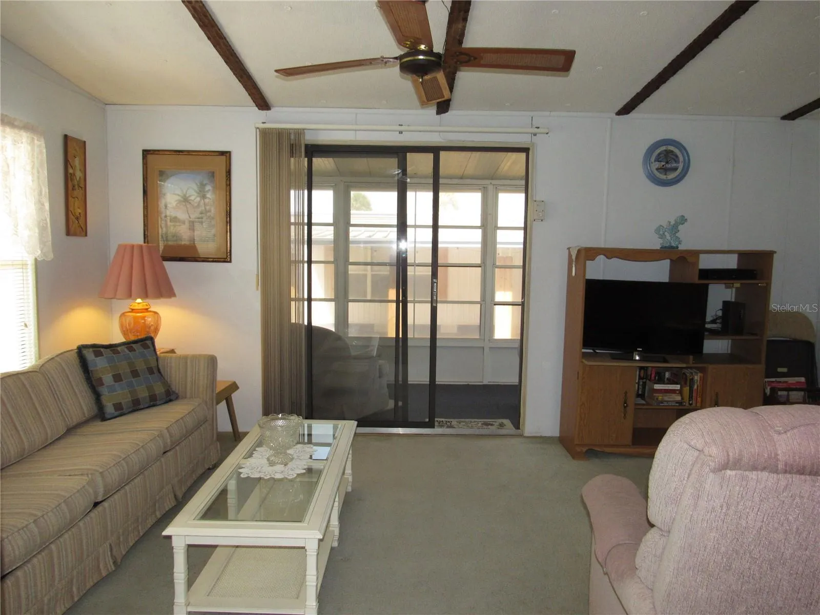 Living room with sliding glass door to raised Florida room.