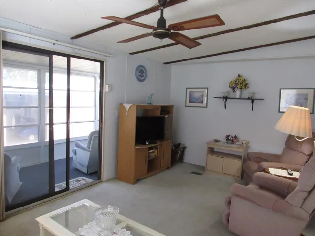 Living room with sliding glass door to raised Florida room.