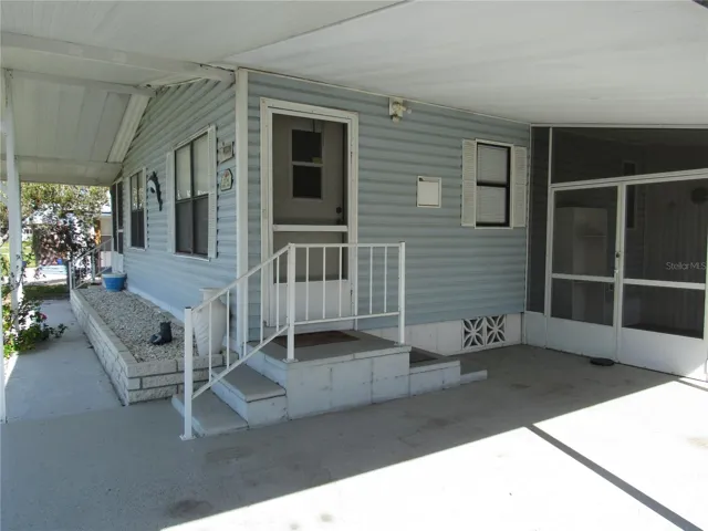 Wide front overhang, sidewalk, brick front planter, main entry, & attached screen porch.