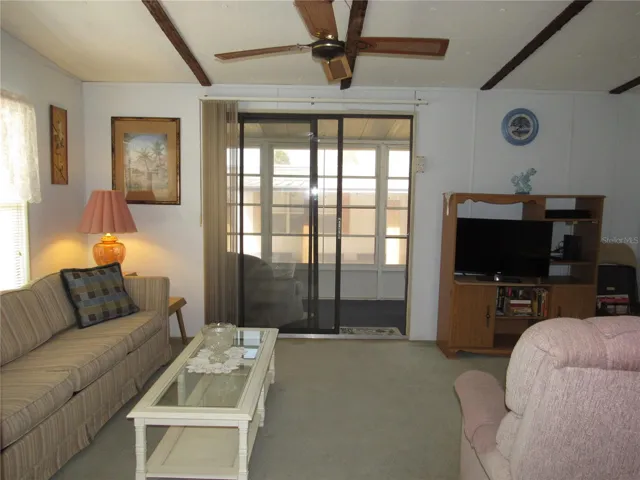 Living room with sliding glass door to raised Florida room.