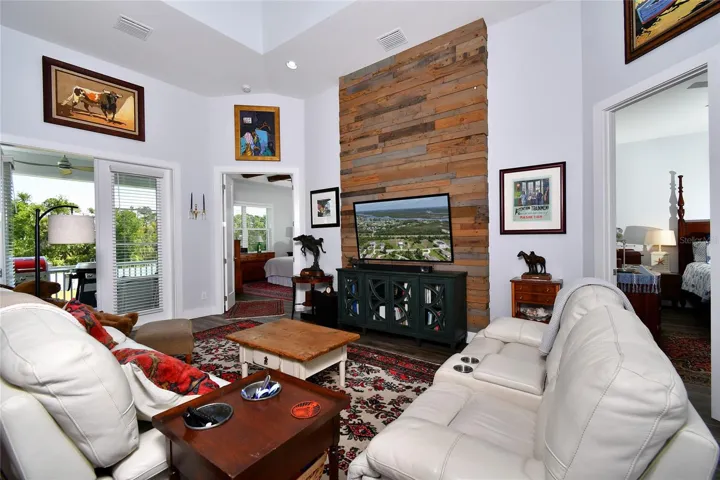 Great Room with view of balcony and primary bedroom