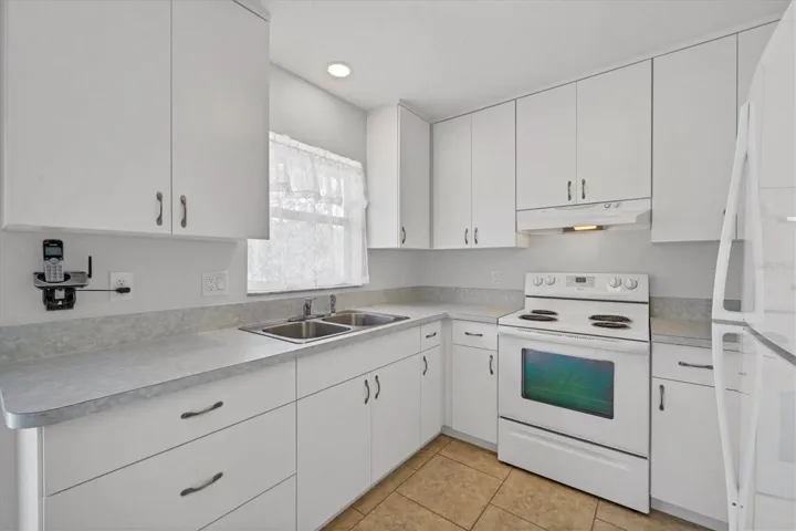 light and bright kitchen with soft close doors and drawers on tall cabinets affording more storage at top shelfs for rarely used items