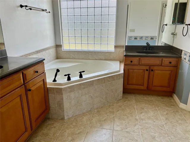 master w/ large soaking tub and oversized glass block window